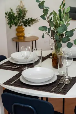 a table with plates and wine glasses on it at 1 bedroom flat in Nicosia