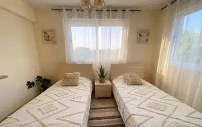 two beds in a room with a window at Summer Breeze apt by Nissi Beach in Ayia Napa