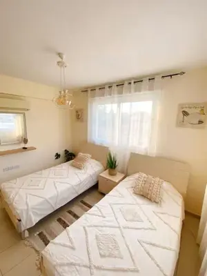 a living room with two beds and a window at Summer Breeze apt by Nissi Beach in Ayia Napa