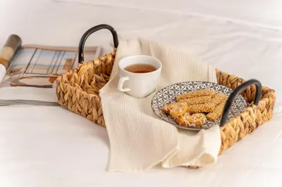 a plate of food and a cup of coffee on a bed at Seafront 1 bedroom flat in Limassol
