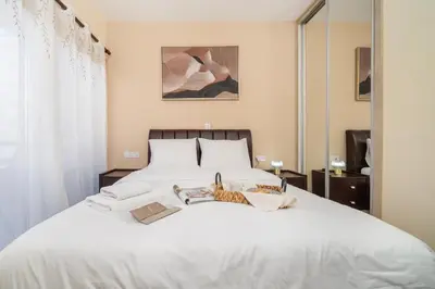 a bedroom with a white bed with a cat on it at Seafront 1 bedroom flat in Limassol