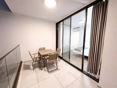 a dining room with a table and chairs and a bedroom at Luna Mare in Limassol