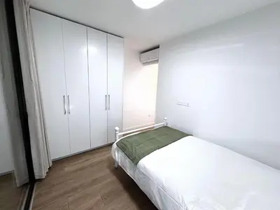 a bedroom with a bed and white cabinets at Luna Mare in Limassol