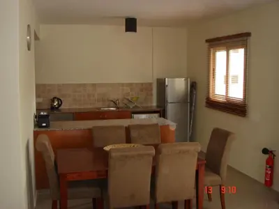 a kitchen with a table and chairs and a refrigerator at 2 Bed apartment with huge balcony overlooking pool in Paralimni