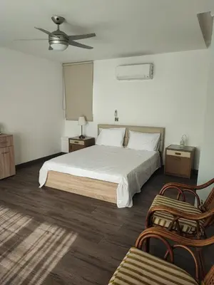 a bedroom with a white bed and two chairs at Bella's Place - Stylish 2BD With large Veranda in Larnaka