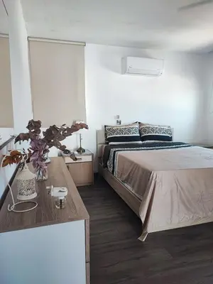 a bedroom with a large bed and a table at Bella's Place - Stylish 2BD With large Veranda in Larnaka