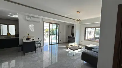 a kitchen and living room with a couch and a table at Bella's Place - Stylish 2BD With large Veranda in Larnaka