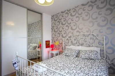 a bedroom with a bed and a wall with patterns at Omerou Apartment in Nicosia