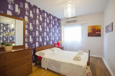 a bedroom with a bed and a dresser and a mirror at Omerou Apartment in Nicosia