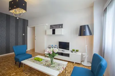 a living room with a table and two blue chairs at Omerou Apartment in Nicosia