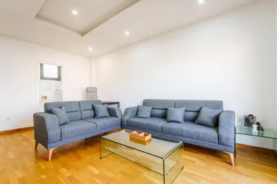 a living room with two blue couches and a coffee table at Fam Glam Comfort Apartment in Larnaka