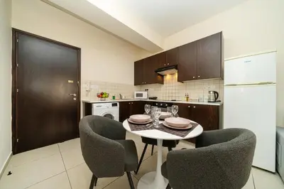 a kitchen with a table and chairs in a kitchen at 1 bedroom flat near center in Nicosia
