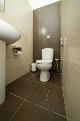 a bathroom with a toilet and a tiled floor at 1 bedroom flat near center in Nicosia
