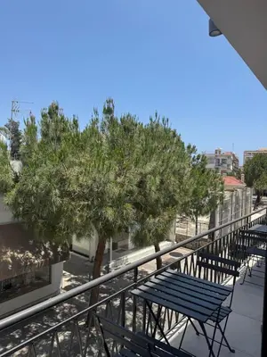 a row of benches on a balcony with a tree at Loft 17 - fully renovated loft in centre in Limassol