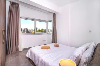 a bedroom with a bed and a large window at Celeste Suites in Limassol