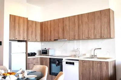 a kitchen with wooden cabinets and a table with a tableablish at Celeste Suites in Limassol