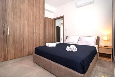 a bedroom with a bed with two towels on it at Celeste Suites in Limassol
