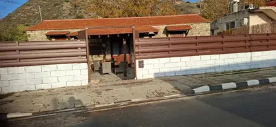 a building with a fence on the side of the street at The river house in Kato Pyrgos