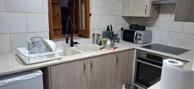 a kitchen counter with a sink and a microwave at The river house in Kato Pyrgos
