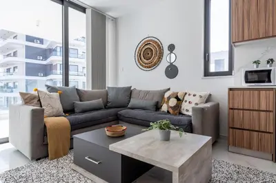 a living room with a couch and a coffee table at Taupe's 2-BR Apartment & Balcony in Larnaca in Livadhia