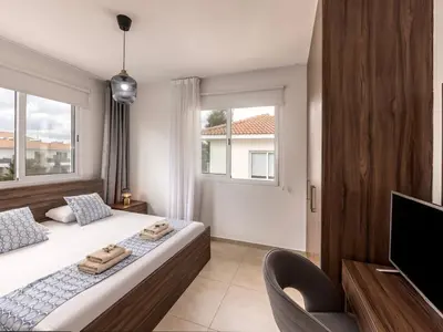 a bedroom with a large bed and a television at Mythical Sands AL14 in Paralimni
