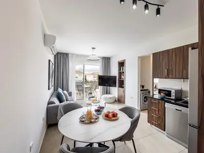 a kitchen and living room with a table and chairs at Mythical Sands AL14 in Paralimni
