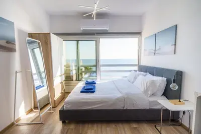 a bedroom with a bed with a view of the ocean at Armonia Seafront Studio in Limassol