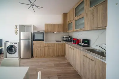 a kitchen with wooden cabinets and a stainless steel refrigerator at Armonia Seafront Studio in Limassol