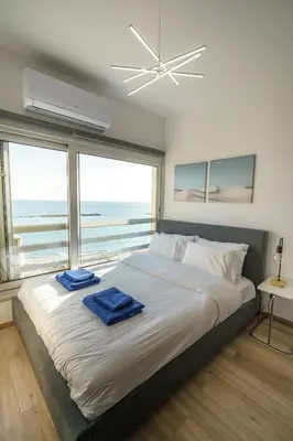 a bedroom with a large bed with two blue towels on it at Armonia Seafront Studio in Limassol