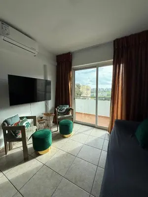 a bedroom with a living room with a large window at Carisa rooms for holiday in Larnaka