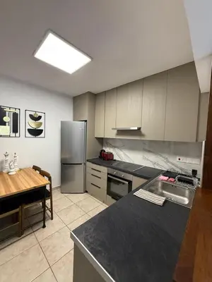 a kitchen with stainless steel appliances and a table at Carisa rooms for holiday in Larnaka