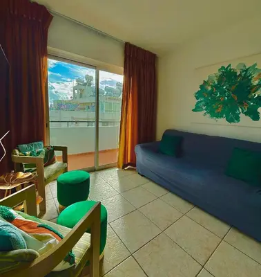 a living room with a blue couch and a large window at Carisa rooms for holiday in Larnaka