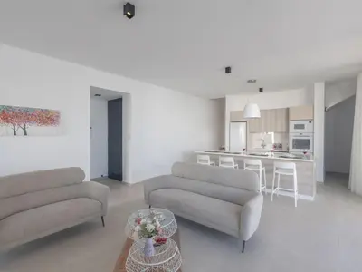 a living room with two couches and a kitchen at Holiday Home Protaras Aqua Pearl Villa AQ16 by Interhome in Protaras
