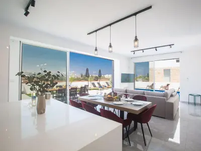 a kitchen and living room with a table and chairs at Holiday Home Protaras Vie Bleu Villa mit Pool- im Zentrum by Interhome in Protaras