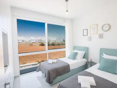 a bedroom with two beds and a large window at Holiday Home Protaras Vie Bleu Villa mit Pool- im Zentrum by Interhome in Protaras