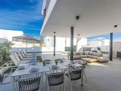 a patio with a table and chairs and a couch at Holiday Home Protaras Aqua Pearl Villa AQ18 mit Poolheizung by Interhome in Protaras