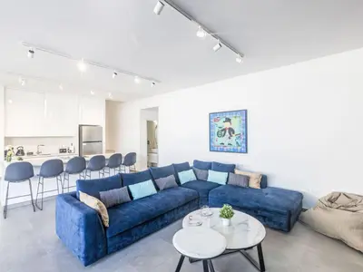 a living room with a blue couch and a table at Holiday Home Protaras Aqua Pearl Villa AQ18 mit Poolheizung by Interhome in Protaras