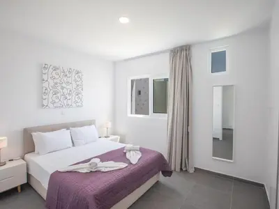 a white bedroom with a bed with a purple blanket at Holiday Home Bleu Vie in Protaras by Interhome in Protaras