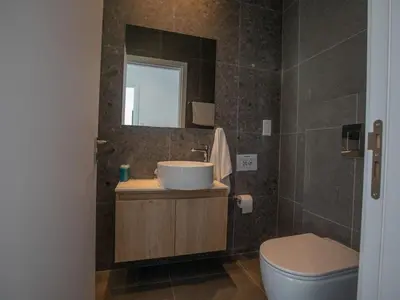 a bathroom with a sink and a toilet and a mirror at Holiday Home Bleu Vie in Protaras by Interhome in Protaras