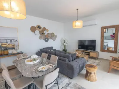 a living room with a table and a couch at Holiday Home Protaras Aqua Pearl Villa AQ01 by Interhome in Protaras