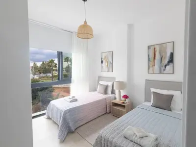two beds in a white room with a window at Holiday Home Protaras Aqua Pearl Villa AQ01 by Interhome in Protaras