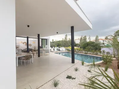 a white house with a swimming pool and a dining area at Holiday Home Protaras Aqua Pearl Villa AQ01 by Interhome in Protaras