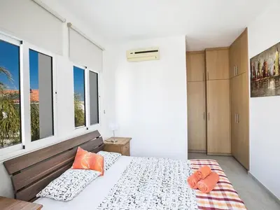 a bedroom with a bed with two orange pillows on it at Holiday Home in Protaras mit privatem Parkplatz by Interhome in Protaras