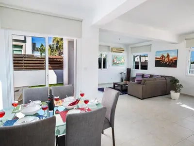 a dining room and living room with a table and chairs at Holiday Home in Protaras mit privatem Parkplatz by Interhome in Protaras