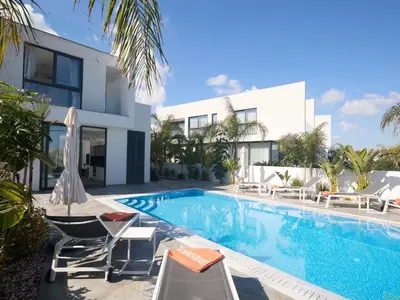 a villa with a swimming pool in front of a building at Holiday Home Protaras Almaria Villa ALM08 by Interhome in Protaras