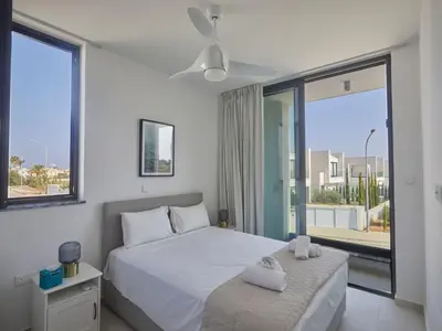 a bedroom with a white bed and a large window at Holiday Home Protaras Almaria Villa ALM08 by Interhome in Protaras