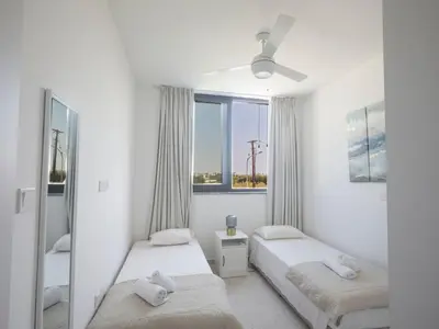 two beds in a white room with a window at Holiday Home Protaras Almaria Villa ALM08 by Interhome in Protaras