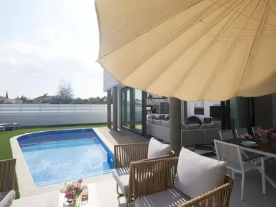 a patio with a swimming pool and an umbrella at Holiday Home Protaras Almaria Villa ALM08 by Interhome in Protaras