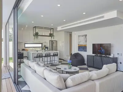 a living room with a large couch and a kitchen at Holiday Home Protaras Almaria Villa ALM08 by Interhome in Protaras