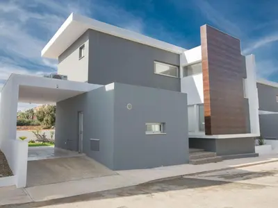 a white house with a brown at Holiday Home 3-Schlafzimmer-Villa mit privatem Pool im Zentrum by Interhome in Protaras